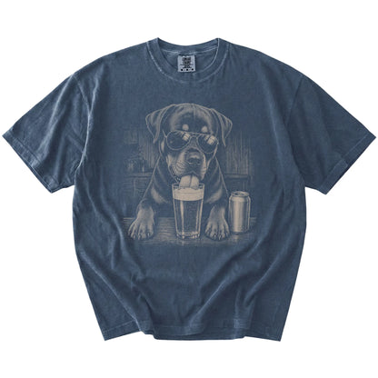 Rottweiler sneaking a drink from a foamy pint at home on a Denim Comfort Colors® t-shirt
