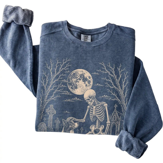 Folded Denim sweatshirt with a skeleton petting a Border Collie in a graveyard