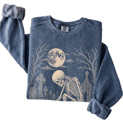 Folded Denim sweatshirt with a skeleton petting a Chihuahua in a graveyard