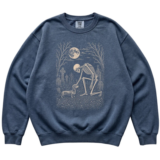 Skeleton petting a Dachshund in a graveyard on a Denim sweatshirt