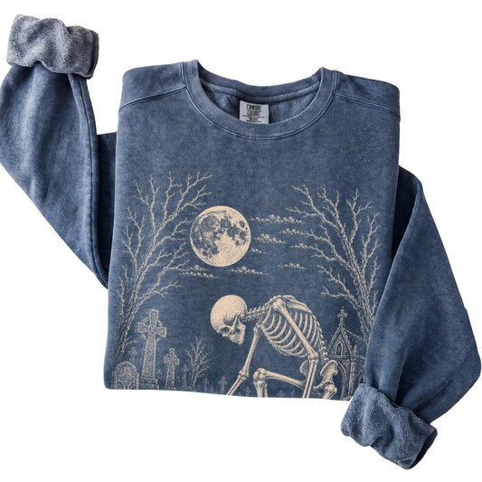 Folded Denim sweatshirt with a skeleton petting a Dachshund in a graveyard