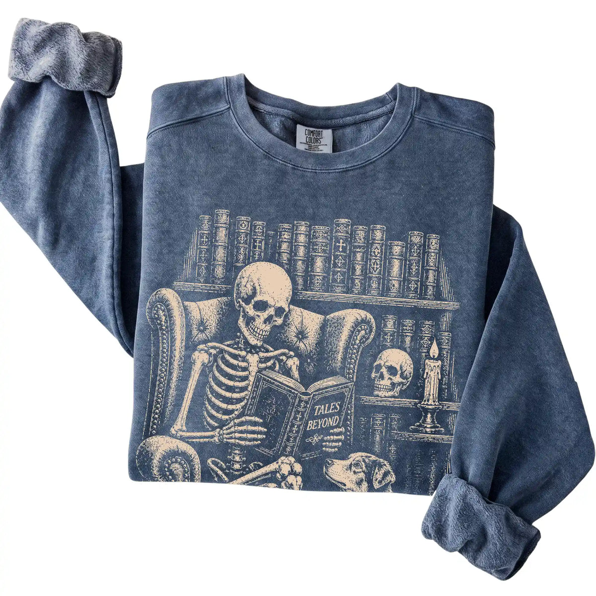 Folded Denim sweatshirt with a skeleton reading Tales Beyond to an Australian Shepherd