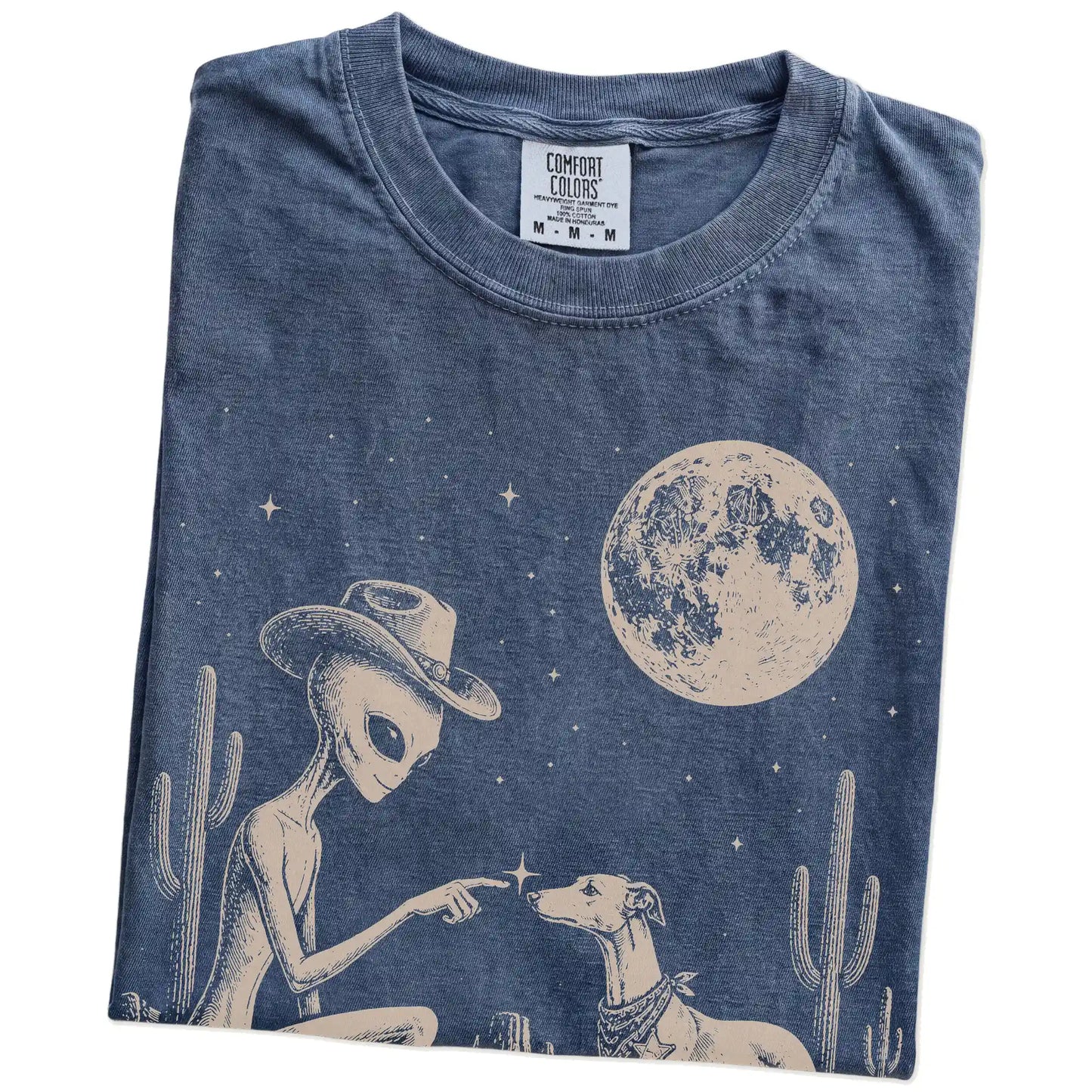 Folded Denim Comfort Colors® T-shirt showing cowboy alien fist-bumping a whippet beneath the moon
