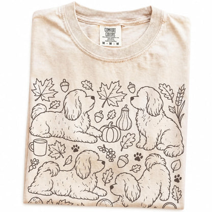 Folded Ivory Comfort Colors® T-shirt showing Havanese dogs with pumpkins, leaves, acorns, and woodland details