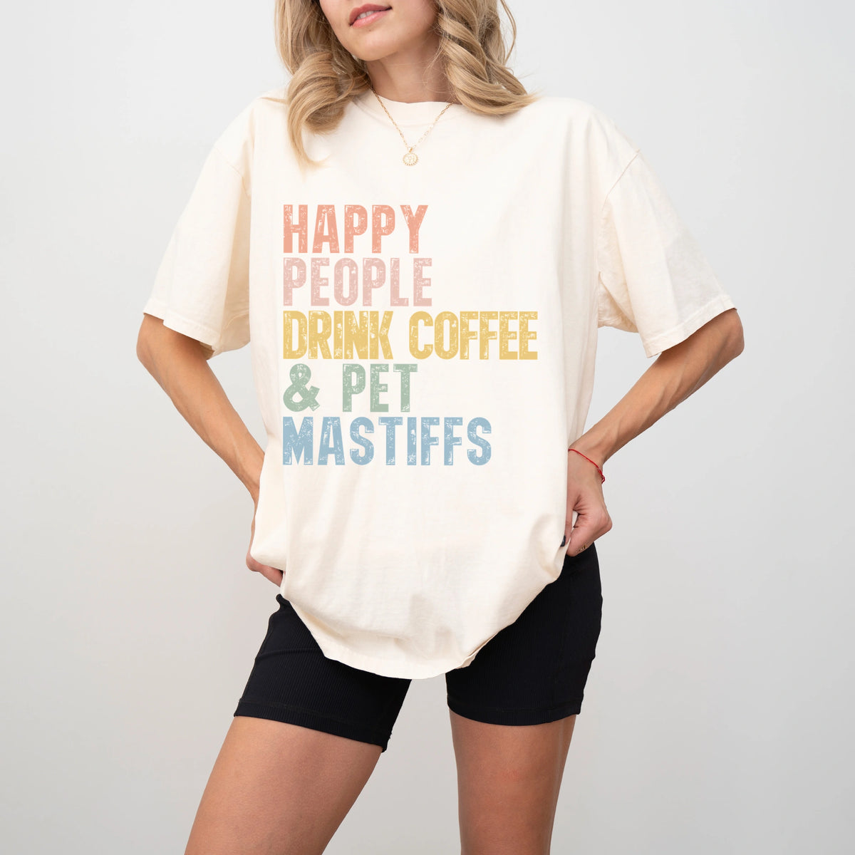 Model wearing a Ivory Comfort Colors® T-shirt featuring Mastiff with coffee and “Happy People Drink Coffee and Pet Dogs” lett