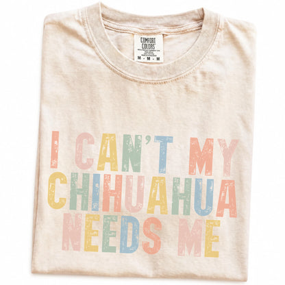 Folded Ivory Comfort Colors® T-shirt showing Chihuahua with “I Can’t, My Dog Needs Me” lettering