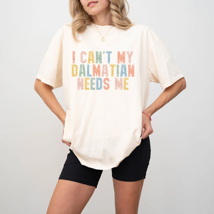 Model wearing a Ivory Comfort Colors® T-shirt featuring Dalmatian with “I Can’t, My Dog Needs Me” lettering
