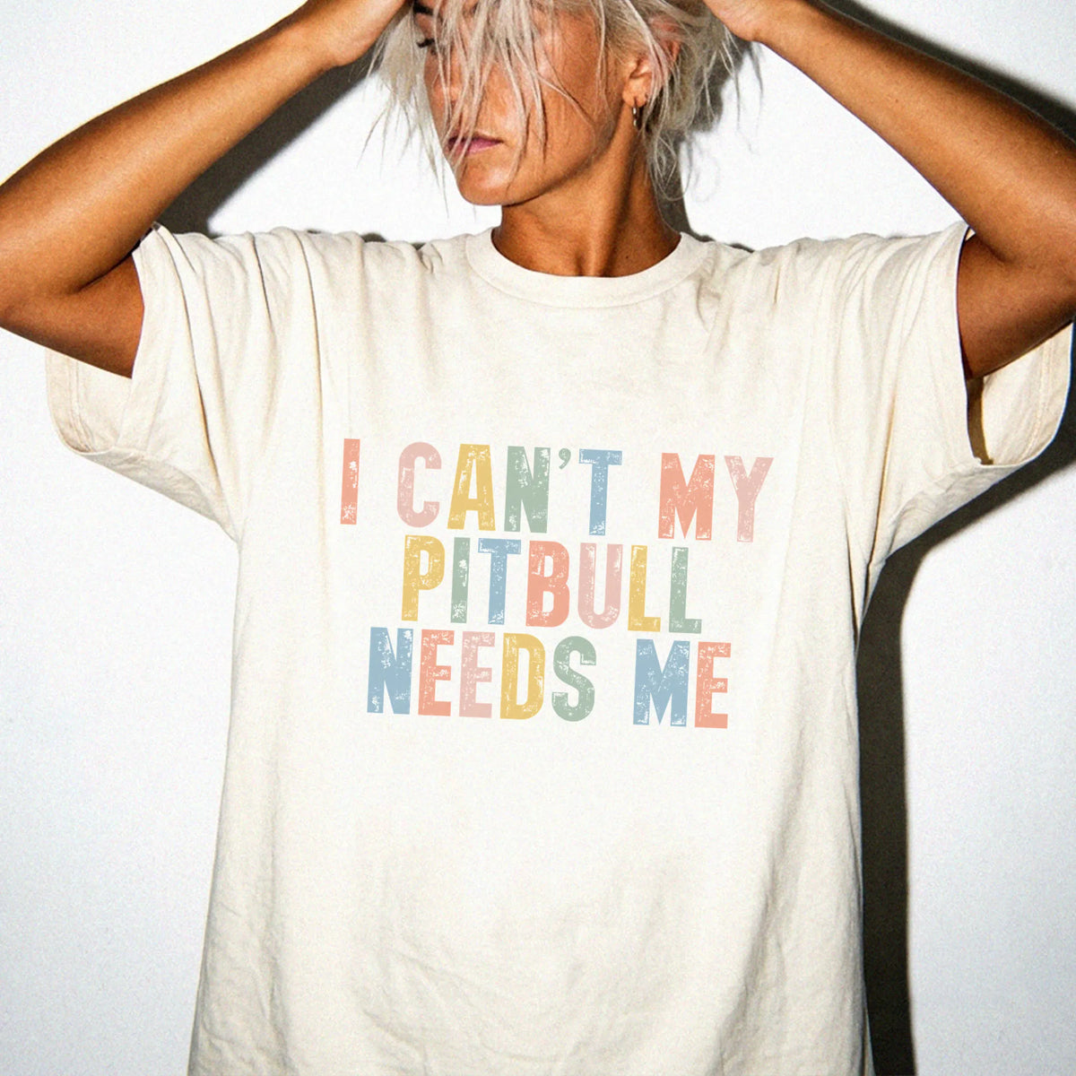 Model wearing a Ivory Comfort Colors® T-shirt featuring Pitbull with “I Can’t, My Dog Needs Me” lettering