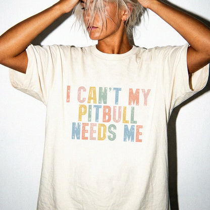 Model wearing a Ivory Comfort Colors® T-shirt featuring Pitbull with “I Can’t, My Dog Needs Me” lettering