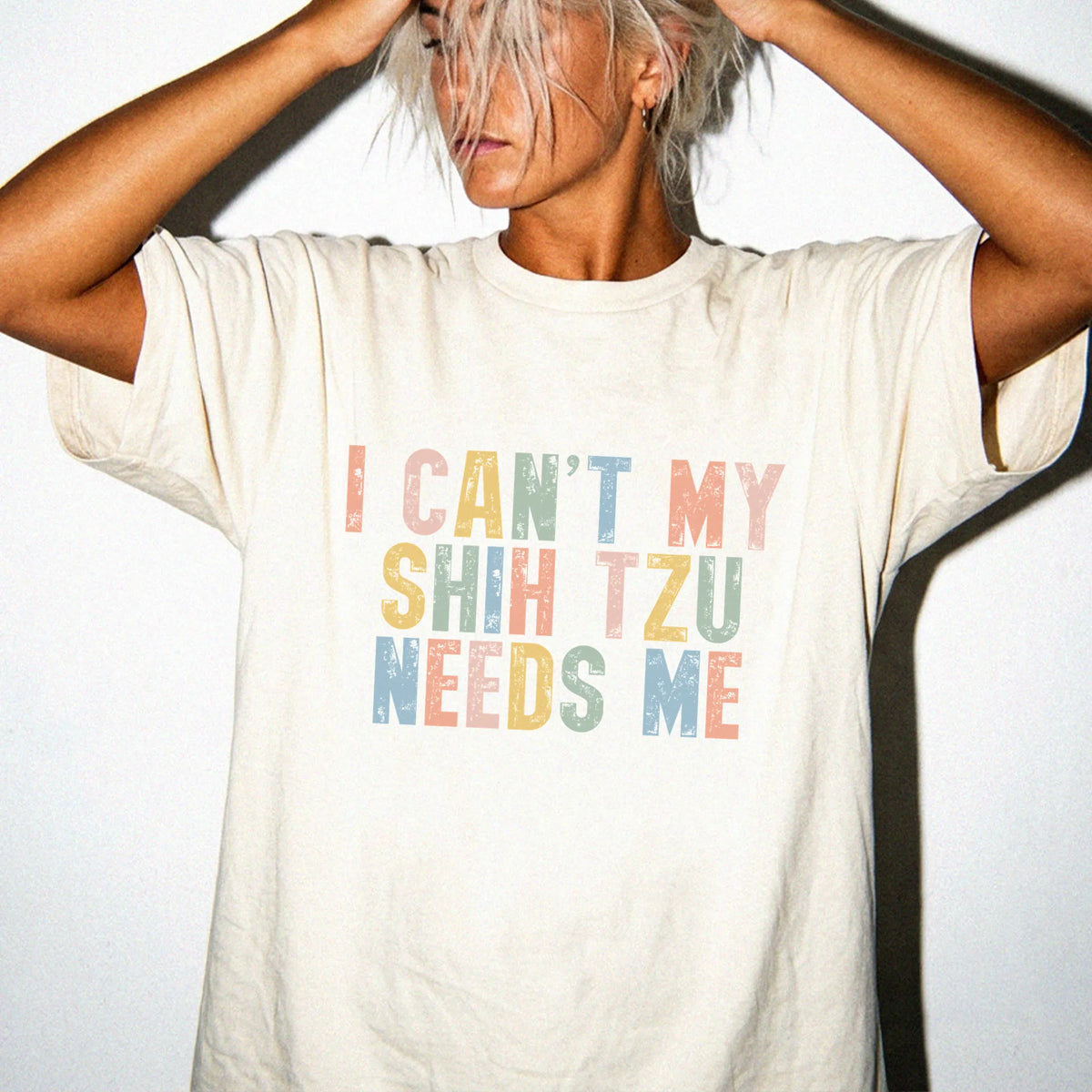 Model wearing a Ivory Comfort Colors® T-shirt featuring Shih Tzu with “I Can’t, My Dog Needs Me” lettering