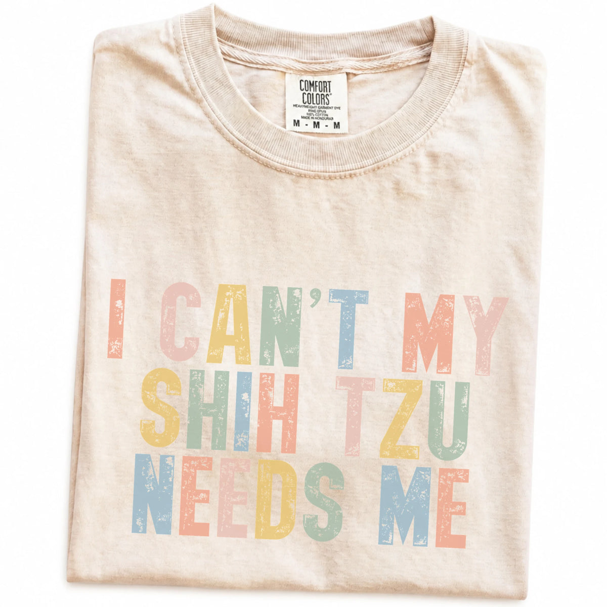 Folded Ivory Comfort Colors® T-shirt showing Shih Tzu with “I Can’t, My Dog Needs Me” lettering