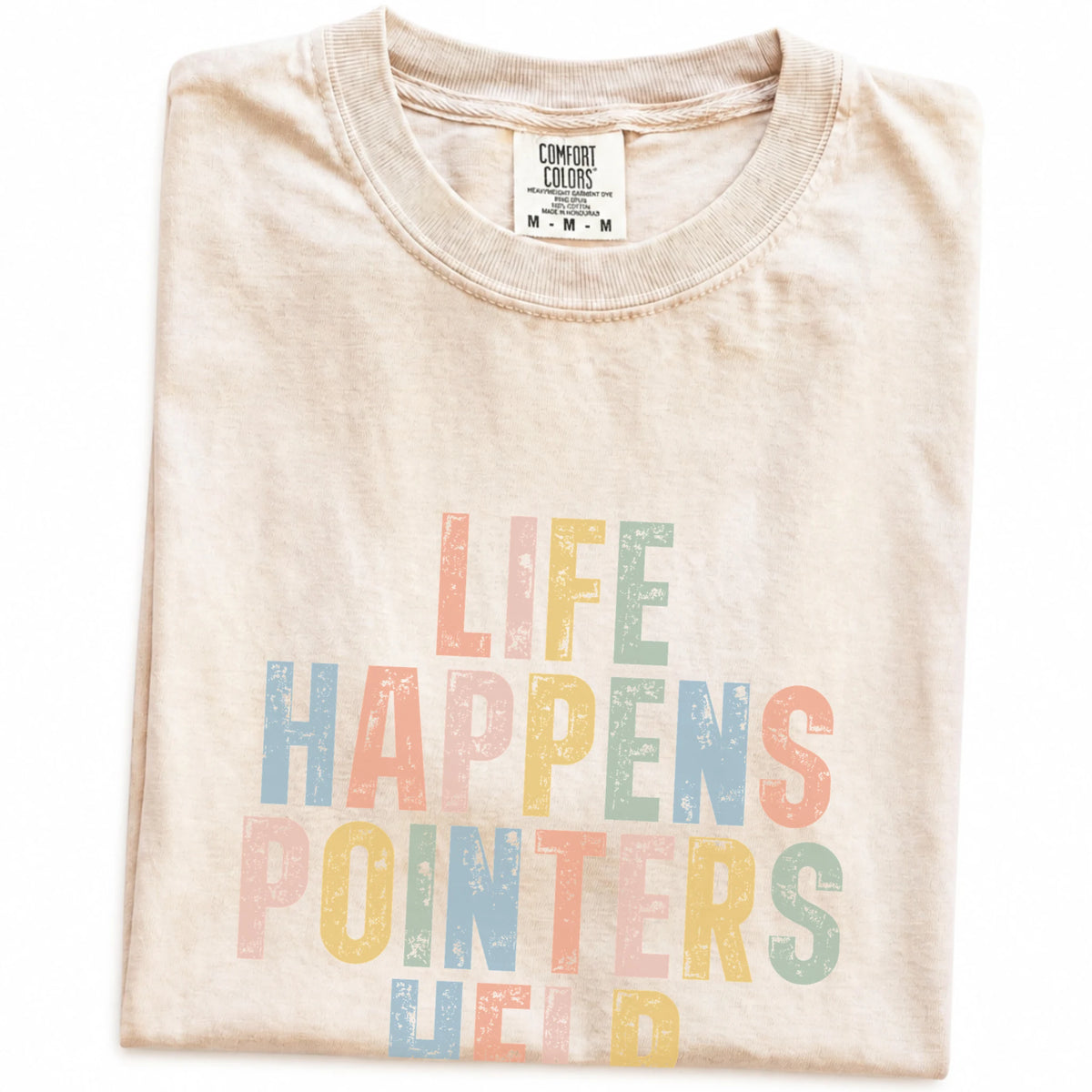 Folded Ivory Comfort Colors® T-shirt showing Pointer making hard days better with “Life Happens, Dogs Help” lettering