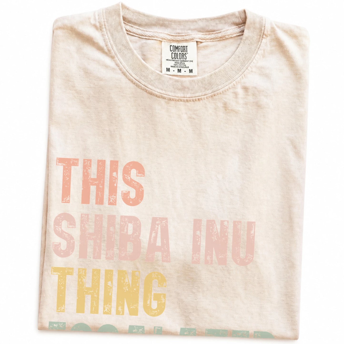 Folded Ivory Comfort Colors® T-shirt showing retro “This Shiba Inu Thing Escalated Quickly” lettering