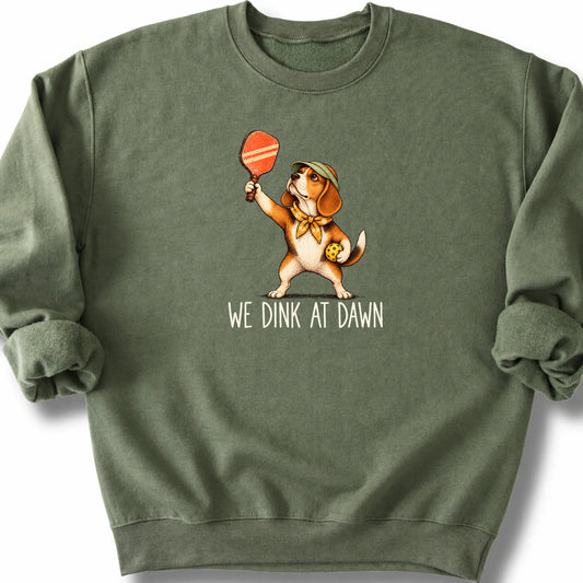 Beagle with a pickleball paddle and ball on a Military Green Gildan® sweatshirt with We Dink at Dawn text