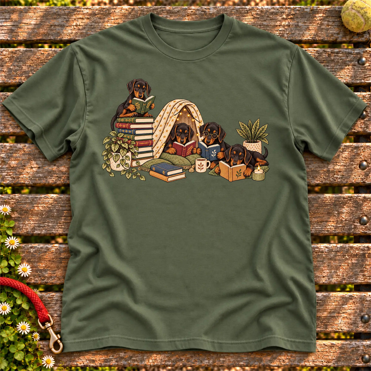 Doberman puppies reading books in a cozy blanket fort on a Military Green T-shirt