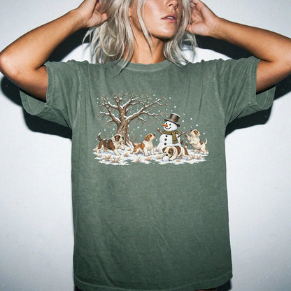 American Bulldog puppies playing in snow with a snowman on a Moss T-shirt worn by a model