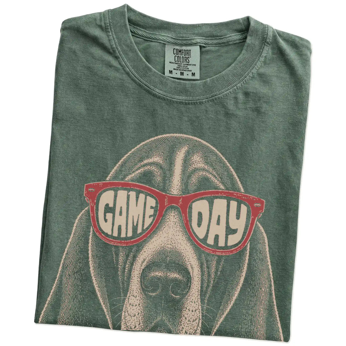 Folded Moss Comfort Colors® T-shirt showing basset hound wearing red game day sunglasses