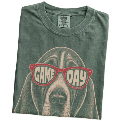 Folded Moss Comfort Colors® T-shirt showing basset hound wearing red game day sunglasses