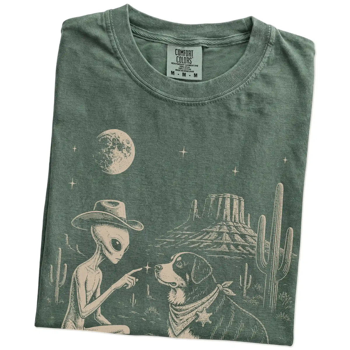 Folded Moss Comfort Colors® T-shirt showing cowboy alien fist-bumping a bernese mountain dog beneath the moon