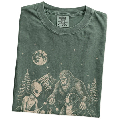 Folded Moss Comfort Colors® T-shirt showing Bernese Mountain Dog camping with Bigfoot and an alien
