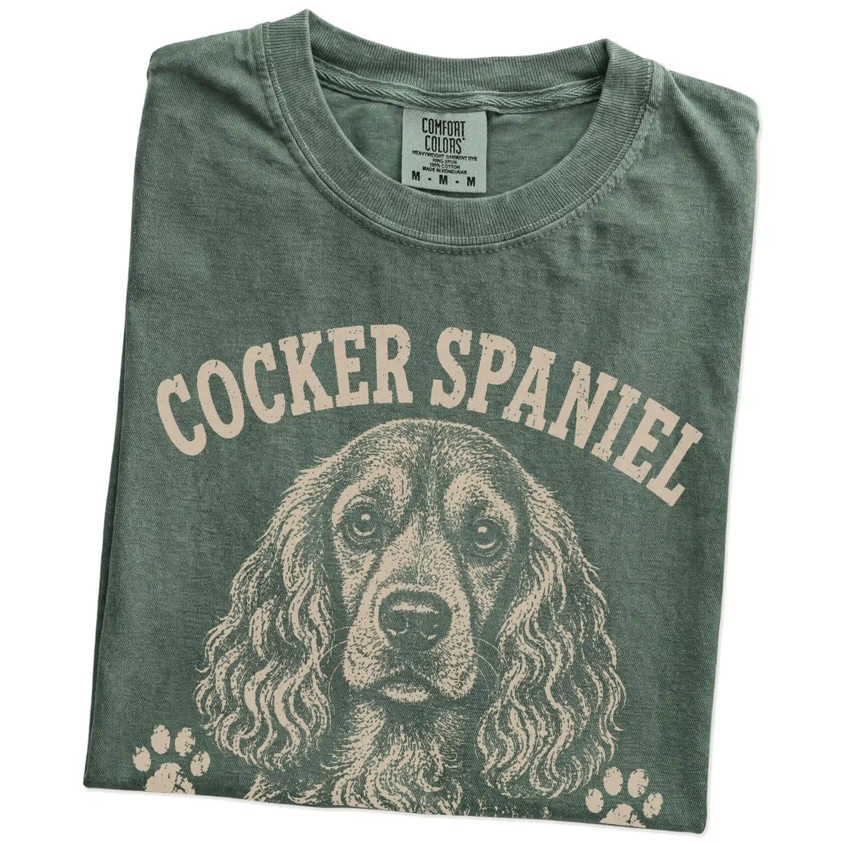 Folded Moss Comfort Colors® T-shirt showing Cocker Spaniel design with “Big Feelings, Better Hair” lettering