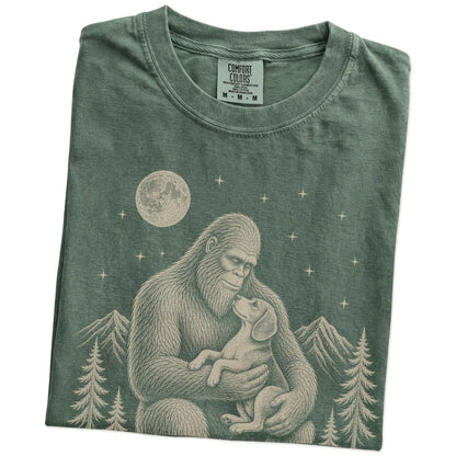 Folded Moss Comfort Colors® T-shirt showing Bigfoot holding a Beagle