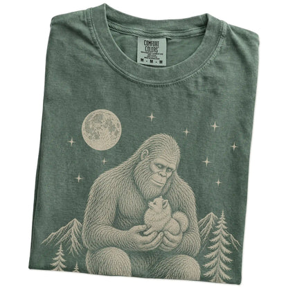 Folded Moss Comfort Colors® T-shirt showing Bigfoot holding a Pomeranian