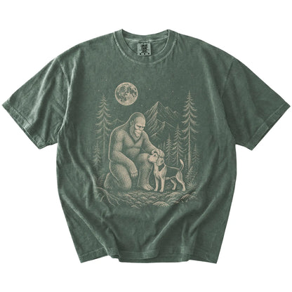 Bigfoot petting a Beagle beneath the moon in a pine forest on a Moss Comfort Colors® T-shirt