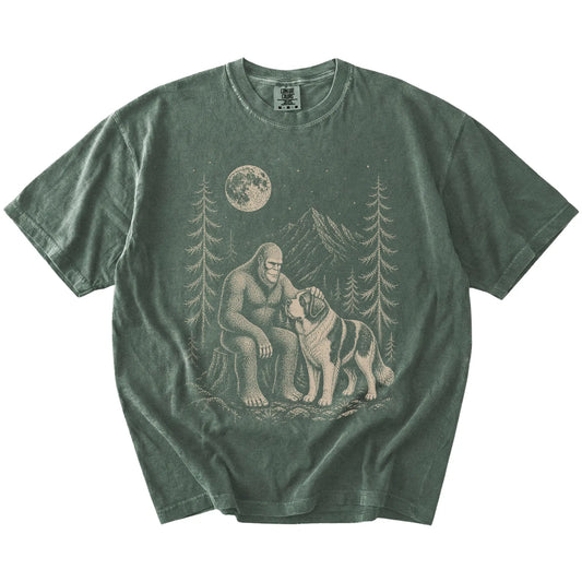 Bigfoot petting a Saint Bernard beneath the moon in a pine forest on a Moss Comfort Colors® T-shirt
