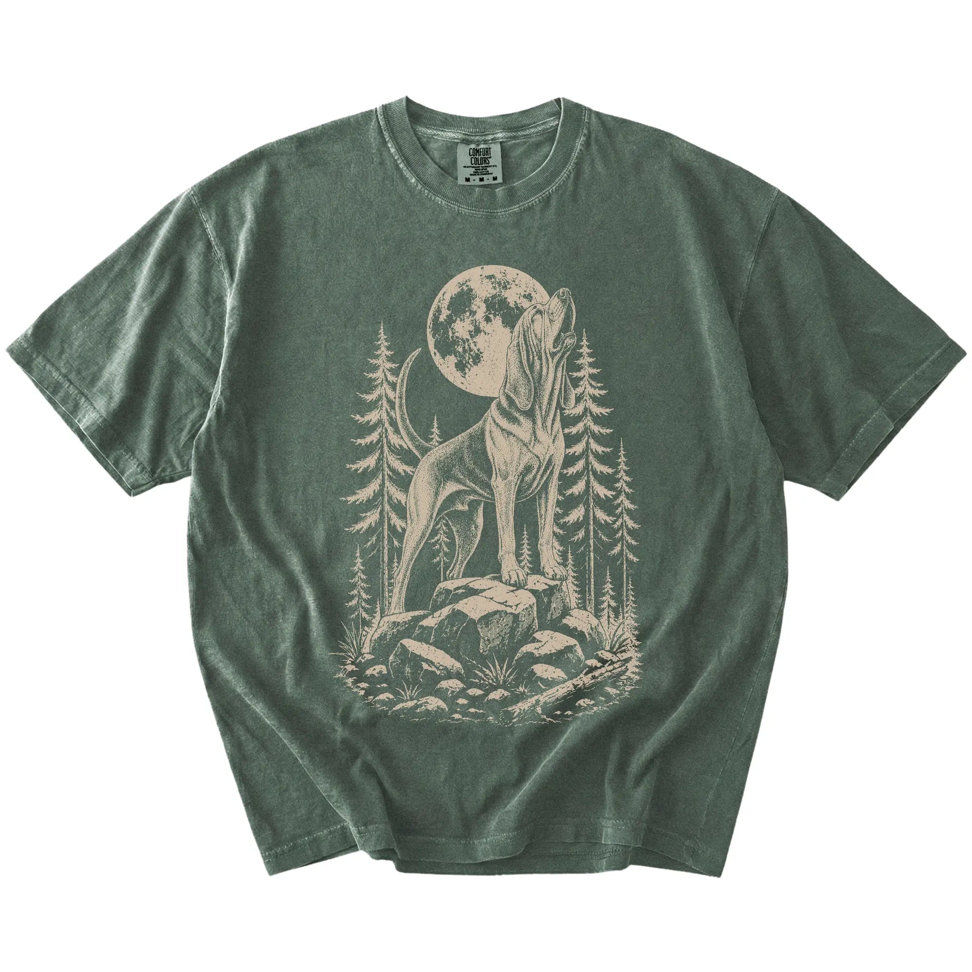 Bloodhound howling beneath the moon and pine trees on a Moss Comfort Colors® T-shirt