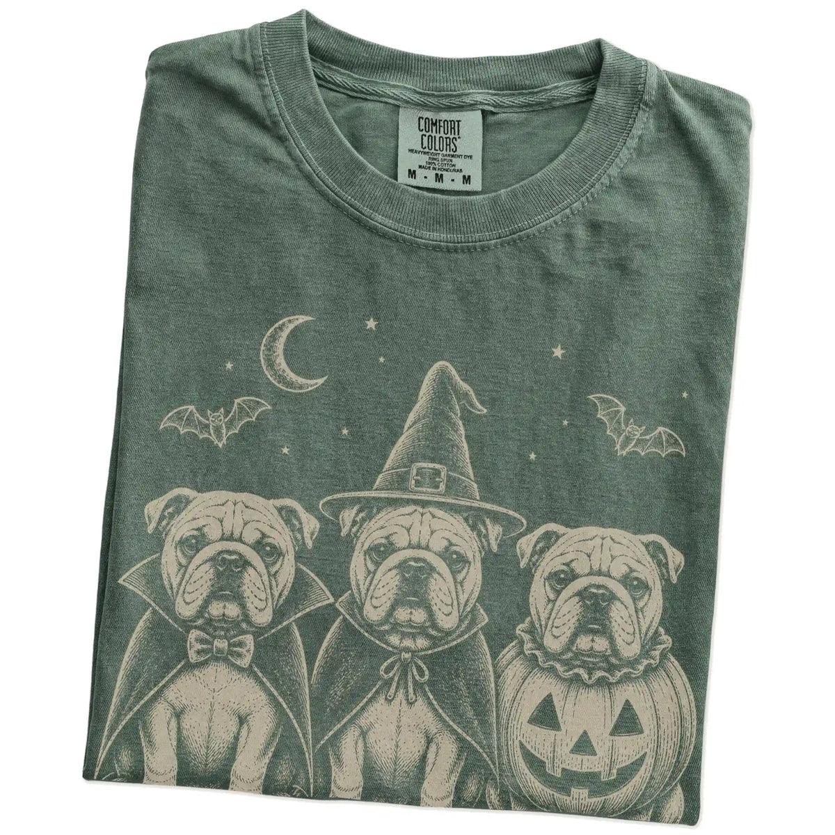 Folded Moss Comfort Colors® T-shirt showing three Bulldog dogs dressed for Halloween beneath bats and a crescent moon