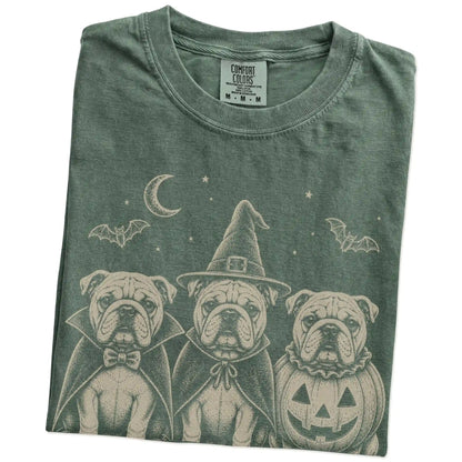 Folded Moss Comfort Colors® T-shirt showing three Bulldog dogs dressed for Halloween beneath bats and a crescent moon