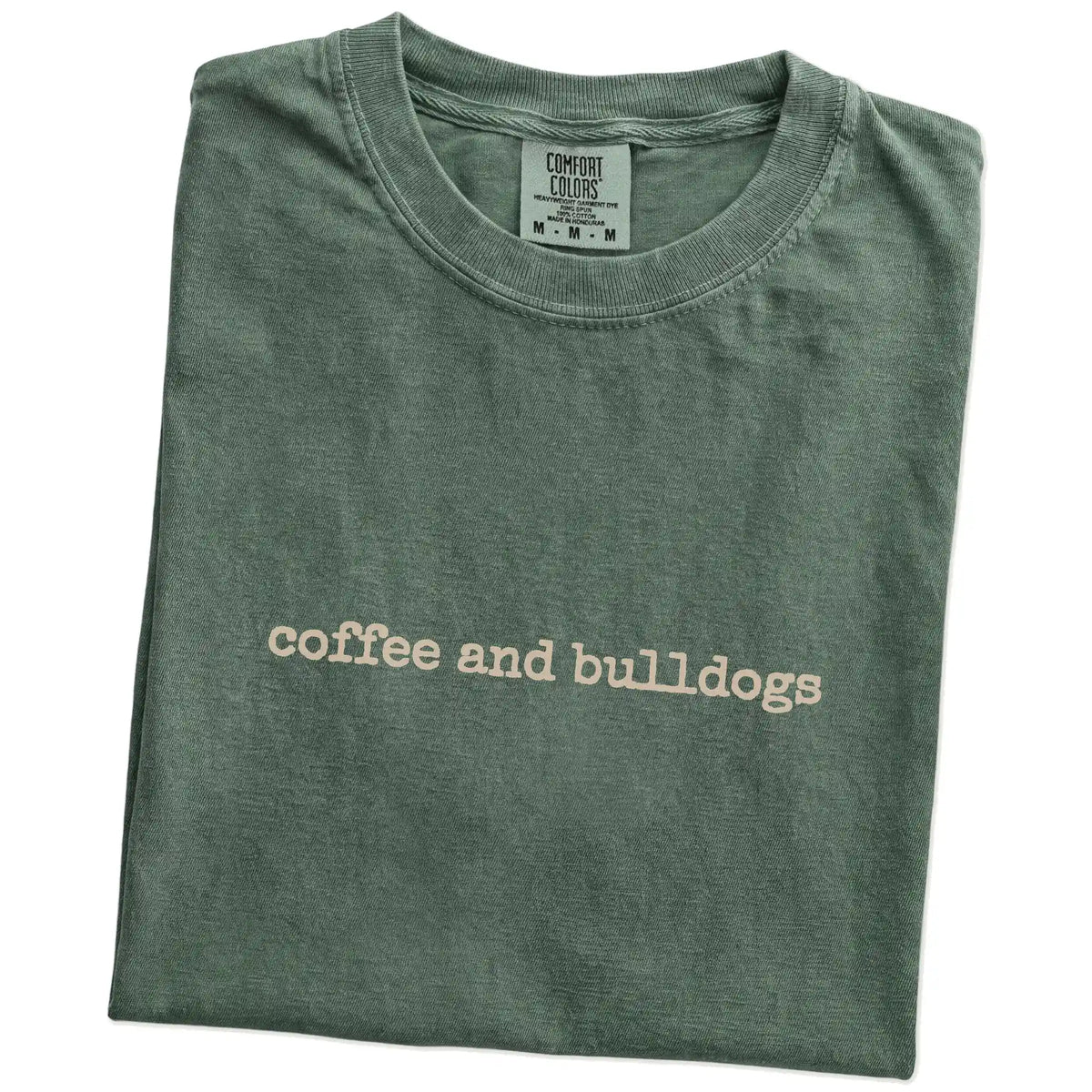 Folded Moss Comfort Colors® T-shirt showing “coffee and bulldogs” retro text