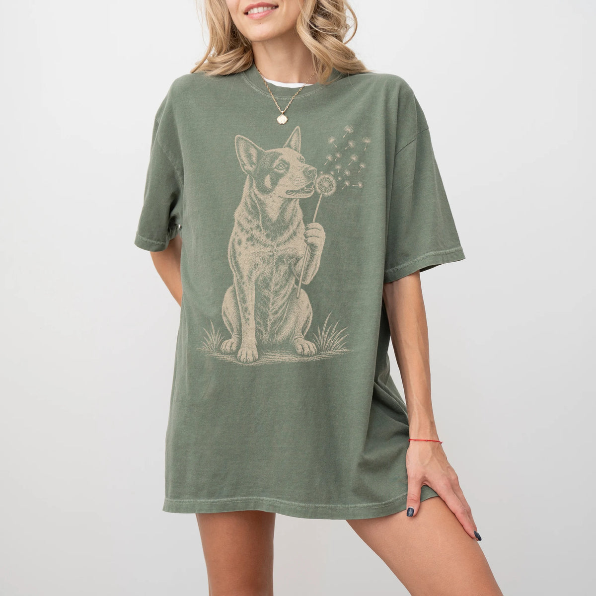 Model wearing a Moss Comfort Colors® T-shirt showing Blue Heeler portrait with drifting dandelion seeds
