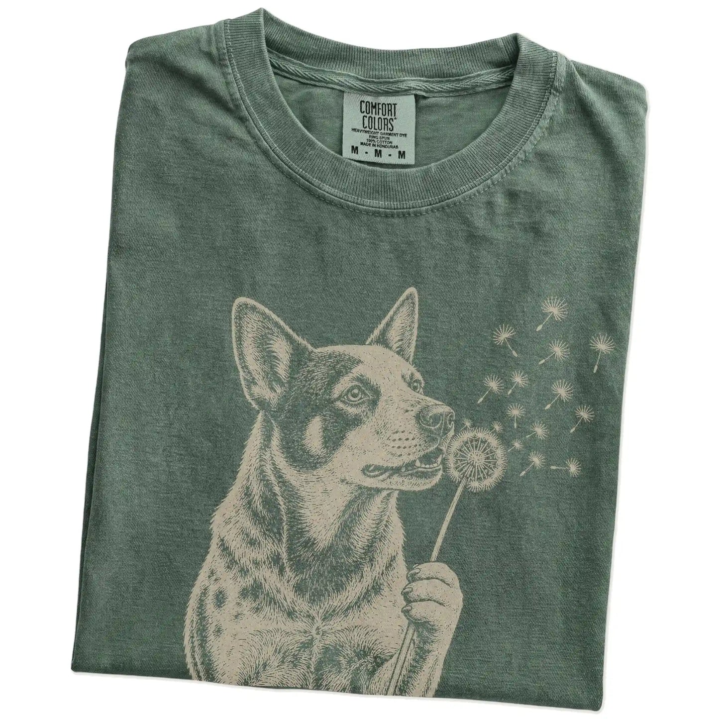 Folded Moss Comfort Colors® T-shirt showing Blue Heeler portrait with drifting dandelion seeds