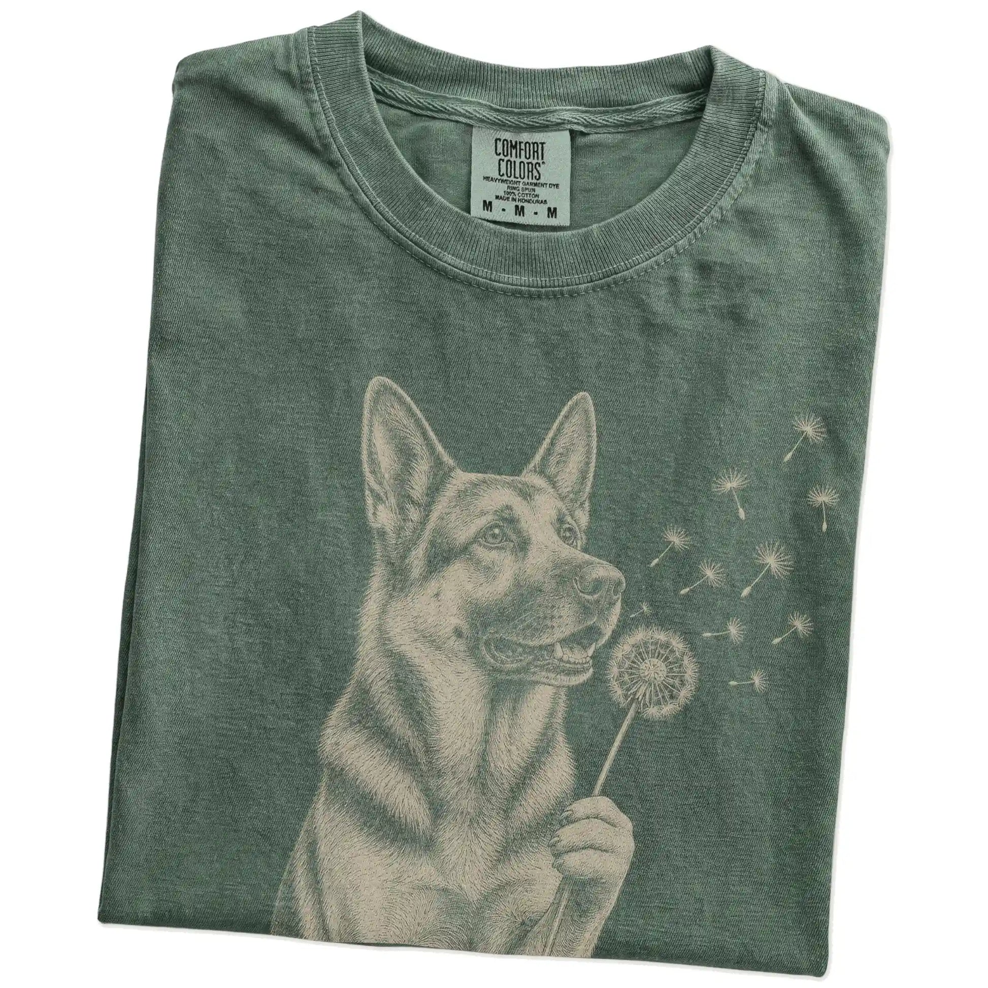 Folded Moss Comfort Colors® T-shirt showing German Shepherd portrait with drifting dandelion seeds