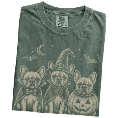 Folded Moss Comfort Colors® T-shirt showing three French Bulldog dogs dressed for Halloween beneath bats and a crescent moon