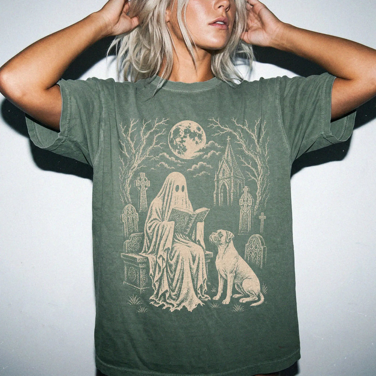 Model wearing a Moss Comfort Colors® T-shirt showing Boxer beside a reading ghost in a moonlit graveyard