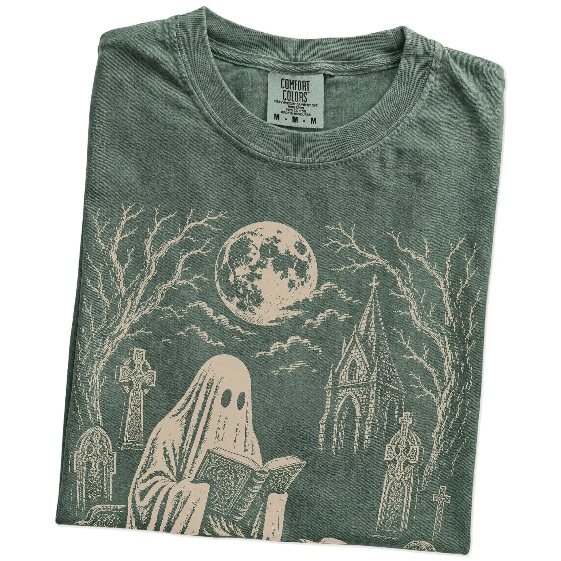 Folded Moss Comfort Colors® T-shirt showing Labrador Retriever beside a reading ghost in a moonlit graveyard