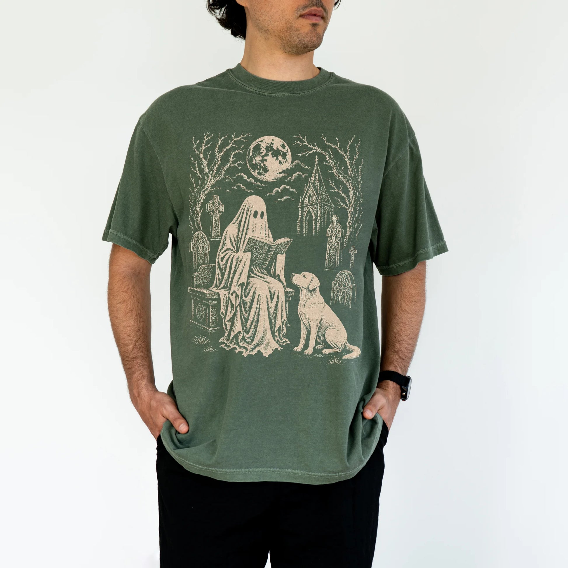 Model wearing a Moss Comfort Colors® T-shirt showing Labrador Retriever beside a reading ghost in a moonlit graveyard