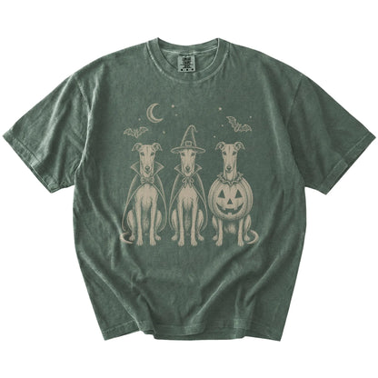 Three Greyhound dogs dressed for Halloween beneath bats and a crescent moon on a Moss Comfort Colors® T-shirt