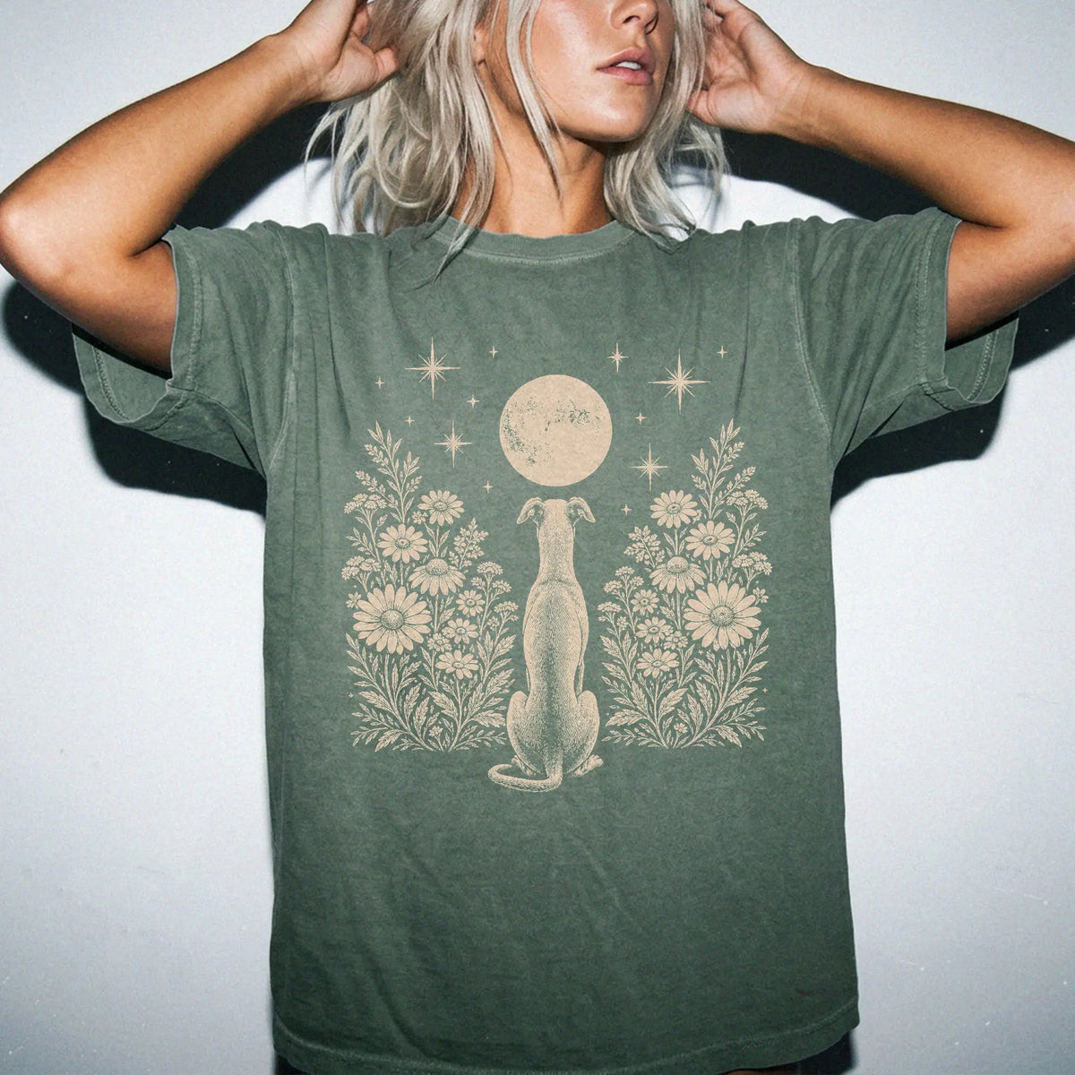 Model wearing a Moss Comfort Colors® T-shirt featuring Greyhound beneath a wildflower moon