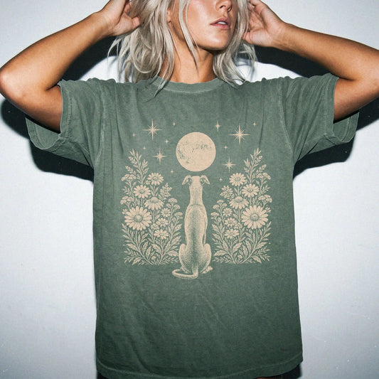 Model wearing a Moss Comfort Colors® T-shirt featuring Greyhound beneath a wildflower moon