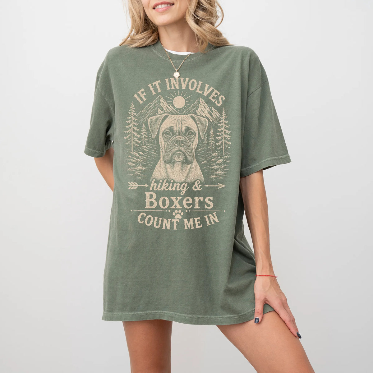 Model wearing a Moss Comfort Colors® T-shirt featuring Boxer hiking design with mountain scenery
