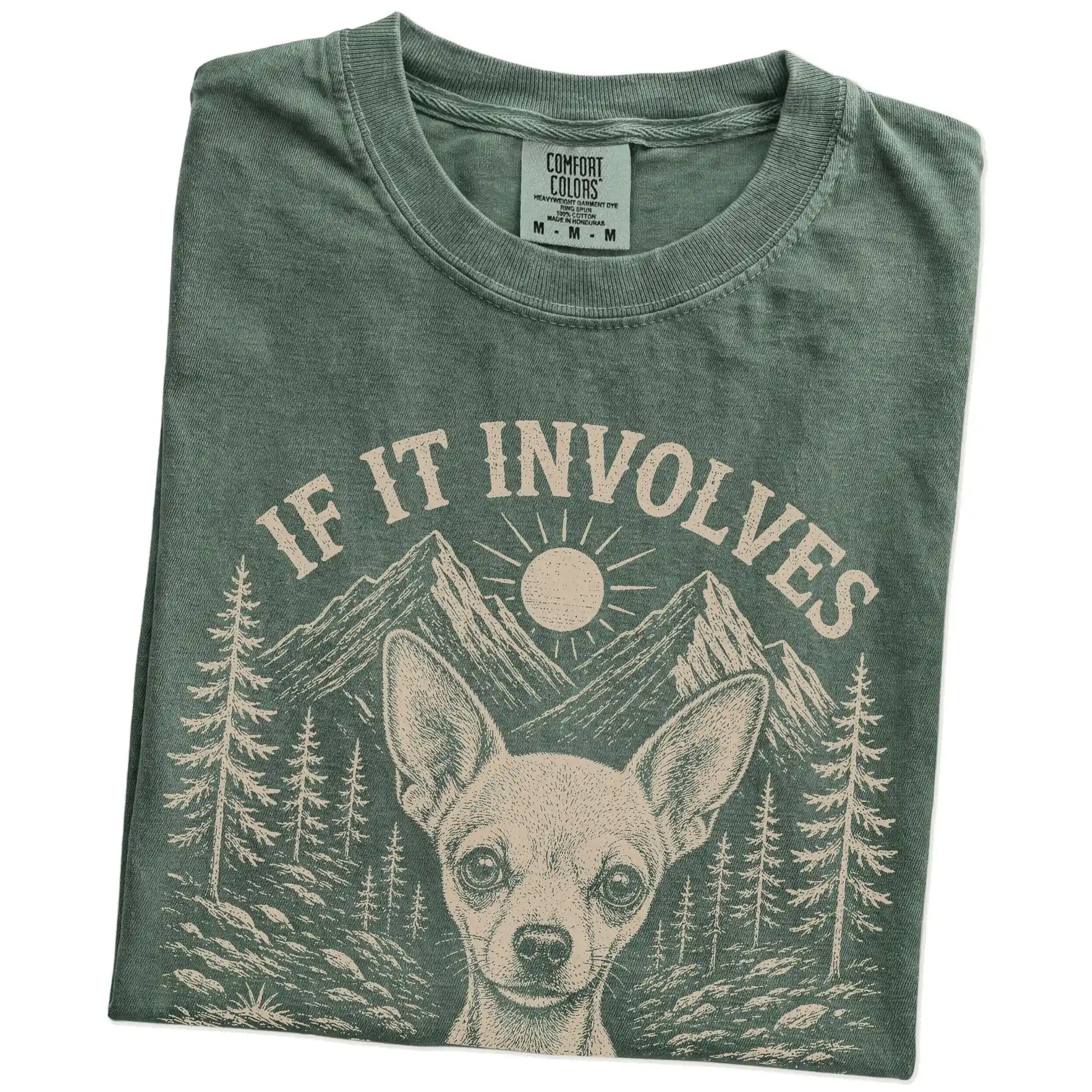 Folded Moss Comfort Colors® T-shirt showing Chihuahua hiking design with mountain scenery