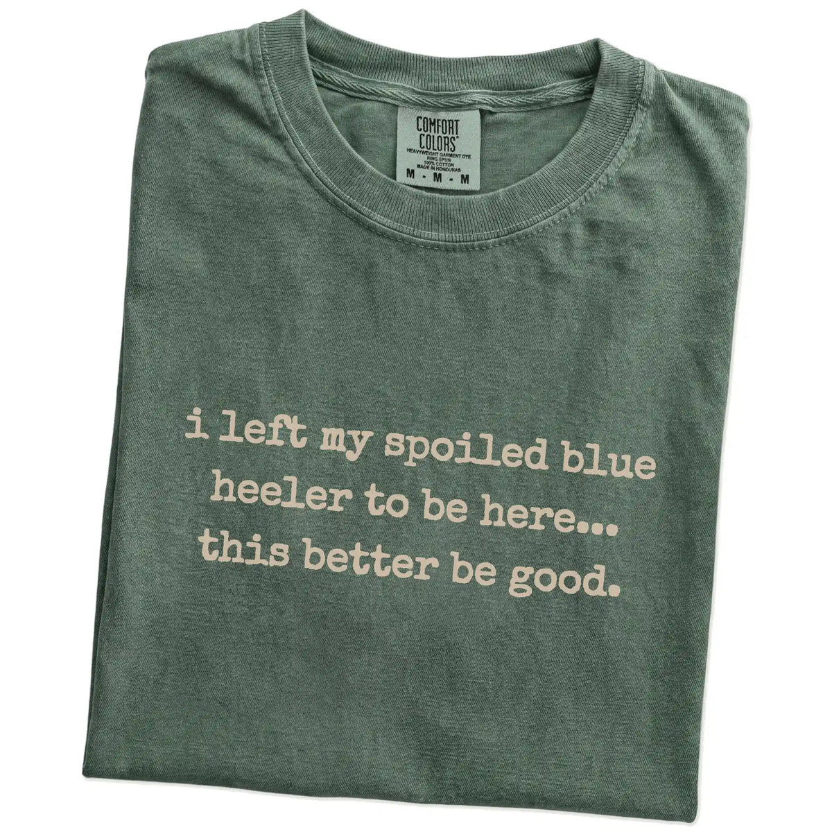 Folded Moss Comfort Colors® T-shirt showing the “I Left My Spoiled Blue Heeler Home” saying