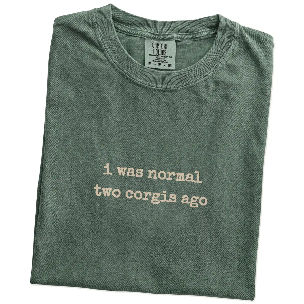 Folded Moss Comfort Colors® T-shirt showing i was normal two corgis ago lettering
