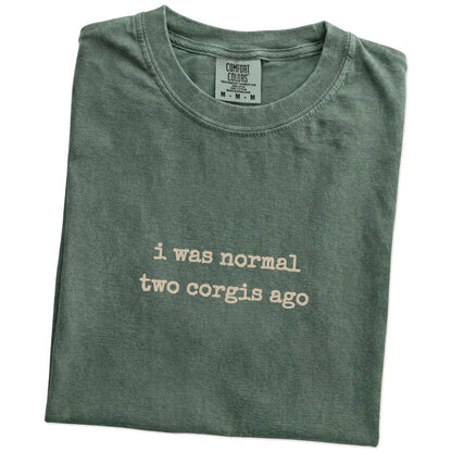 Folded Moss Comfort Colors® T-shirt showing i was normal two corgis ago lettering