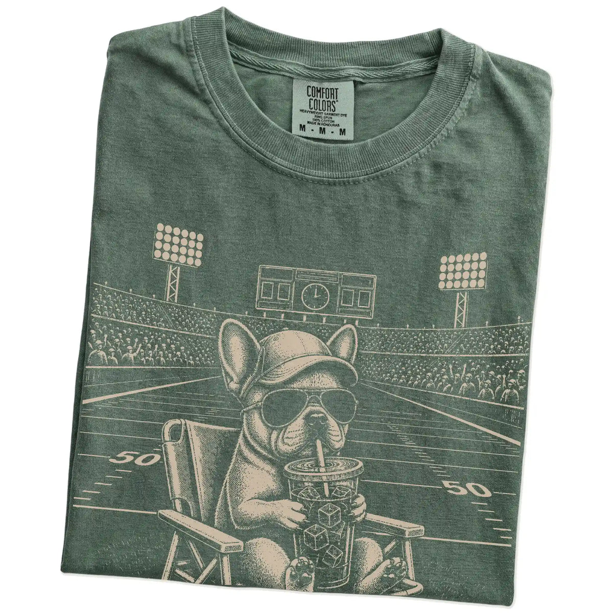 Folded Moss Comfort Colors® T-shirt showing French Bulldog claiming the football field with “I Live Here Now” lettering
