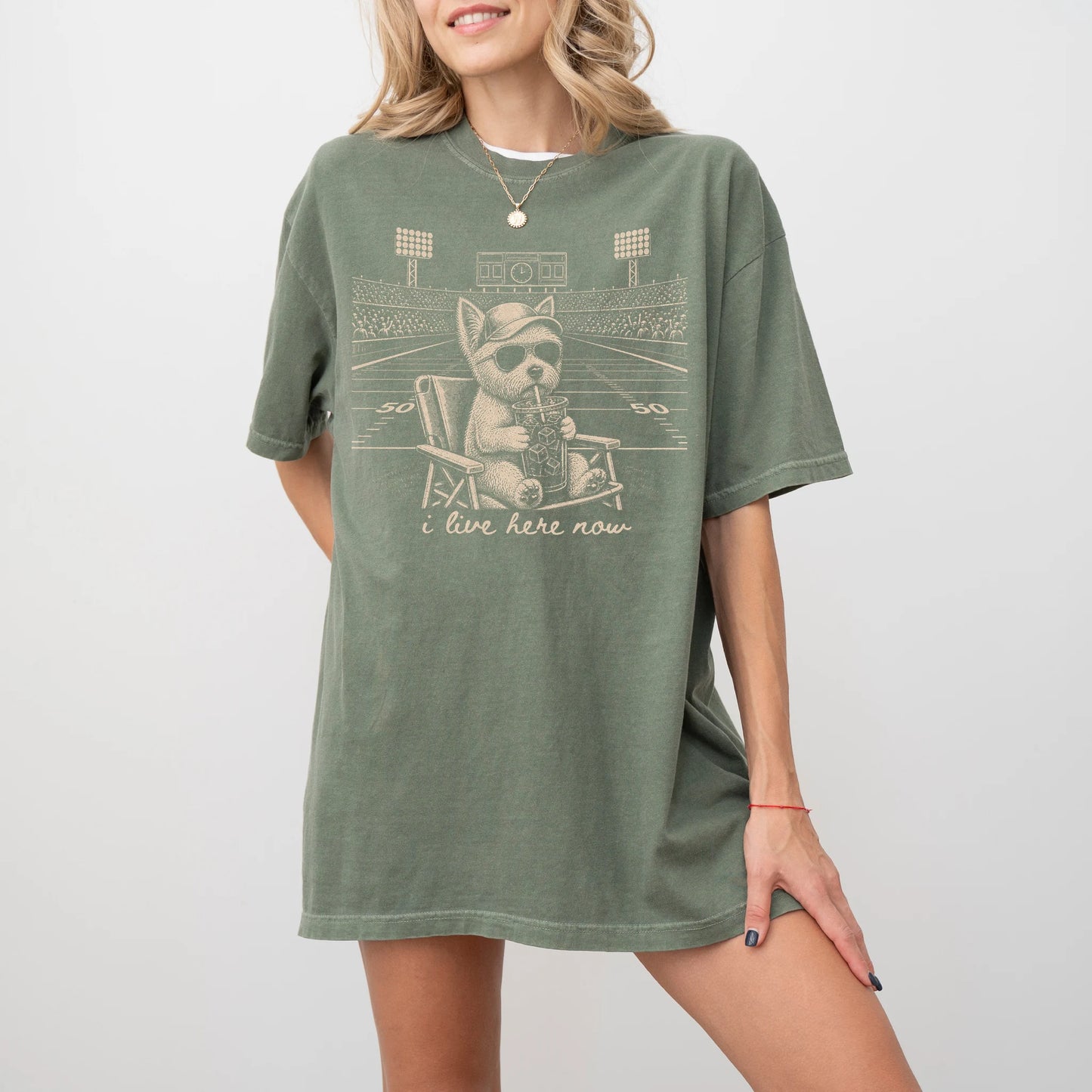 Model wearing a Moss Comfort Colors® T-shirt featuring Westie claiming the football field with “I Live Here Now” lettering